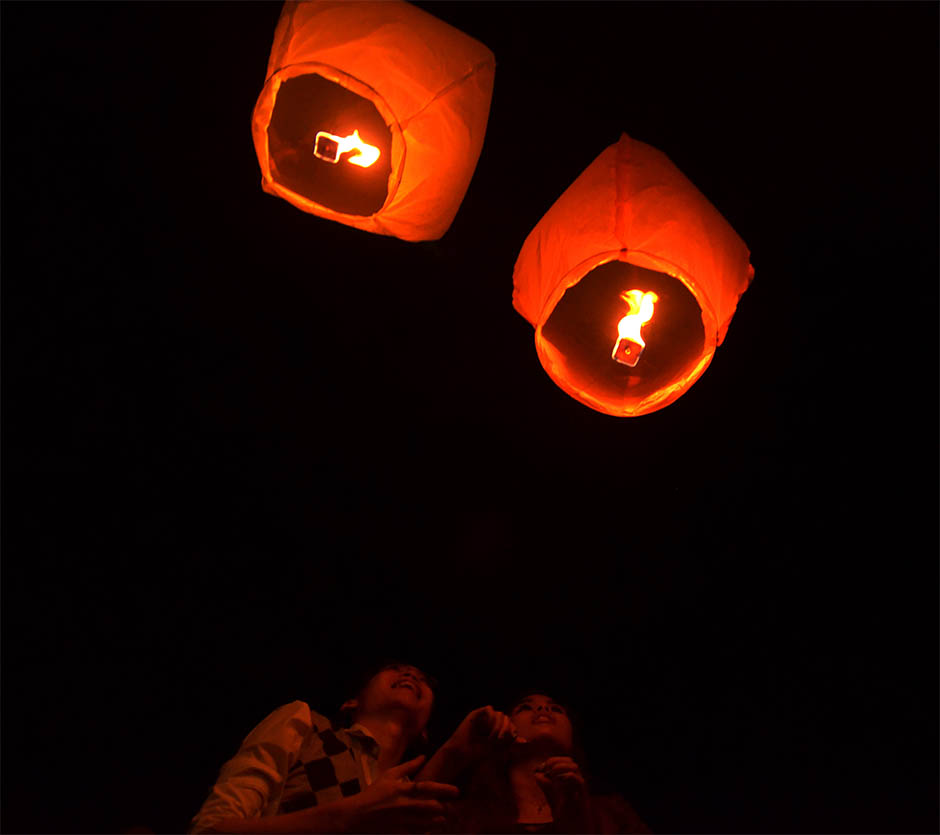 A couple looking at their lanterns after releasing it in the air during the Chap Goh Mei celebration in Petaling Jaya, Kuala Lumpur, February 15, 2014. Chap Goh Mei is a festival celebrated on the 15th day of the first month in lunisolar year in the lunar calendar marking the last day of the lunar New Year celebration. 