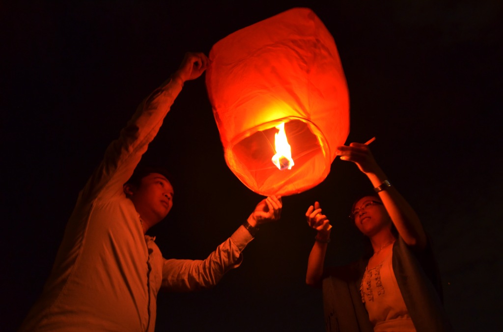 A couple release the lanterns during the Chap Goh Mei celebration in Petaling Jaya, Kuala Lumpur, February 15, 2014. Chap Goh Mei is a festival celebrated on the 15th day of the first month in lunisolar year in the lunar calendar marking the last day of the lunar New Year celebration. 